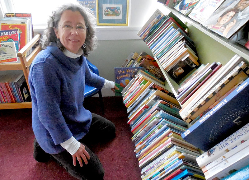 Rosie Bensen, co-manager of the Skidompha Secondhand Book Shop in Damariscotta, shelves books in the children's section of the newly relocated book shop, which is set to open Wednesday, Feb. 1. (Christine LaPado-Breglia photo)