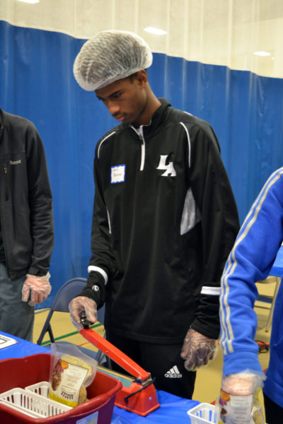 Lincoln Academy student Chris Dennis learns to heat-seal bags of dried macaroni noodles for distribution to local food pantries. (Christine LaPado-Breglia photo)