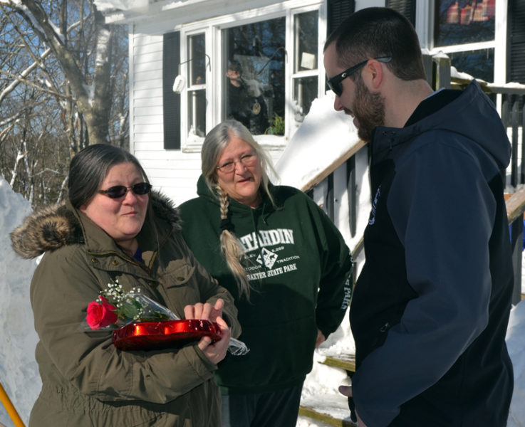 Damariscotta resident Georgia Woodman (left) thanks Matt Poole, of Colby & Gale Inc., for his delivery of flowers and chocolates as her sister, Lori Storer, looks on. On Valentine's Day, Colby & Gale surprised some of its customers with a free refill of their oil tank. (Maia Zewert photo)