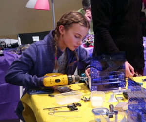 Arden Carleton, one of the student participants in this year's Gizmo Garden program, uses a drill while creating her sailboat race gizmo. The 23 students each created a gizmo, and their creations were linked together to create a Gizmo Water Park. (Photo courtesy Judy Silver)