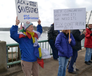 Sharon Sandstrum, an organizer of Lincoln County Indivisible, holds her sign high during a health care-focused protest on the Damariscotta-Newcastle bridge Saturday, Feb. 25. The sign reads "ACA or single payer saves lives #Sanders2020." (Abigail Adams photo)