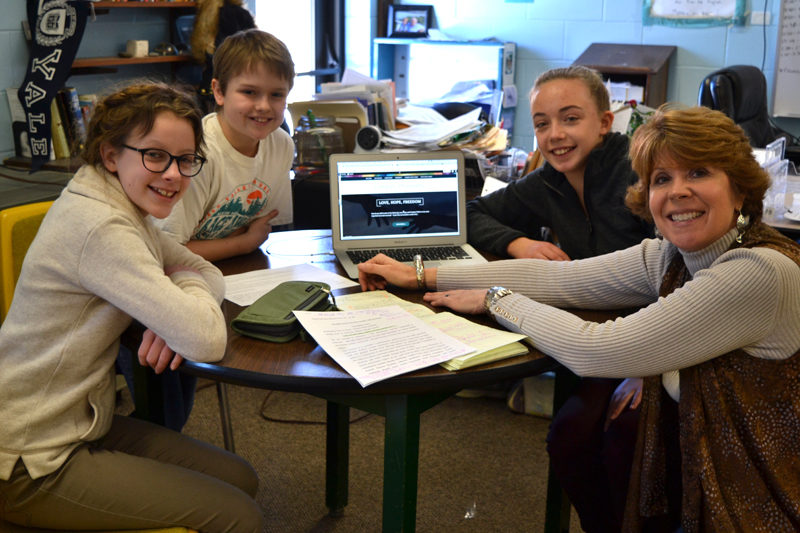 From left: Marina McManus, Andrew Lyndaker, Caitlin Cass, and Anne Plummer chat about the new Great Salt Bay Community School Online Gallery of Arts and Literature in Plummer's writing classroom. Plummer oversees the project, which McManus, Lyndaker, and Cass are thrilled to be involved with. (Christine LaPado-Breglia photo)
