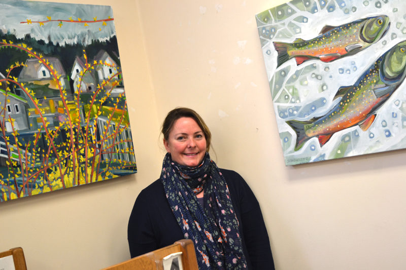 Walpole artist Susan Bartlett Rice stands in a corner of the Bristol Area Library containing two of the paintings in her winter series on display at the library through Tuesday, Feb. 28. (Christine LaPado-Breglia photo)
