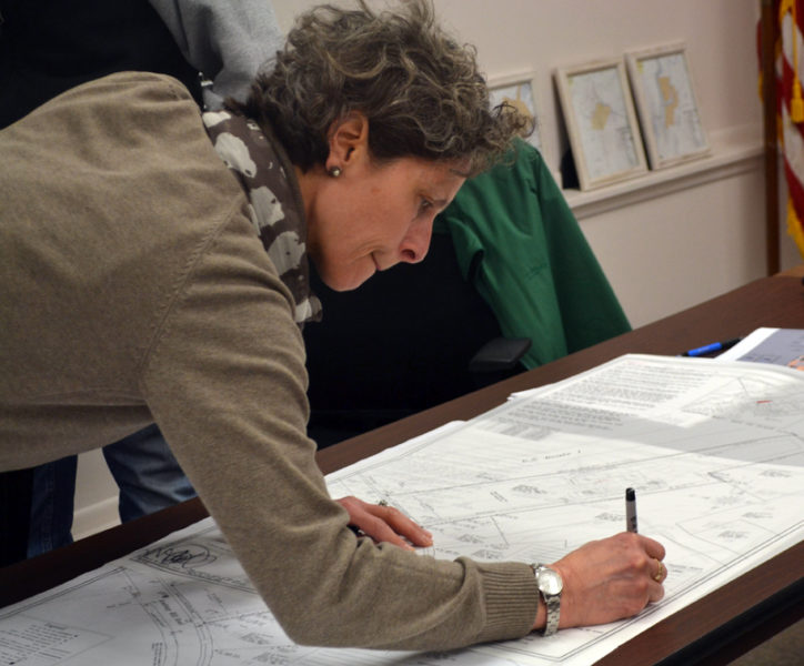 Newcastle Planning Board Chair Bonnie Stone signs a site plan from Mobius Inc. on Thursday, Feb. 16. The board unanimously approved Mobius' application to convert a house and barn into apartments at 21 Academy Hill Road. (Maia Zewert photo)