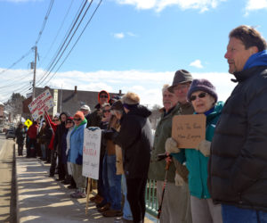 People stand on the Damariscotta-Newcastle bridge during a rally in support of constitutional rights Sunday, March 19. (Maia Zewert photo)