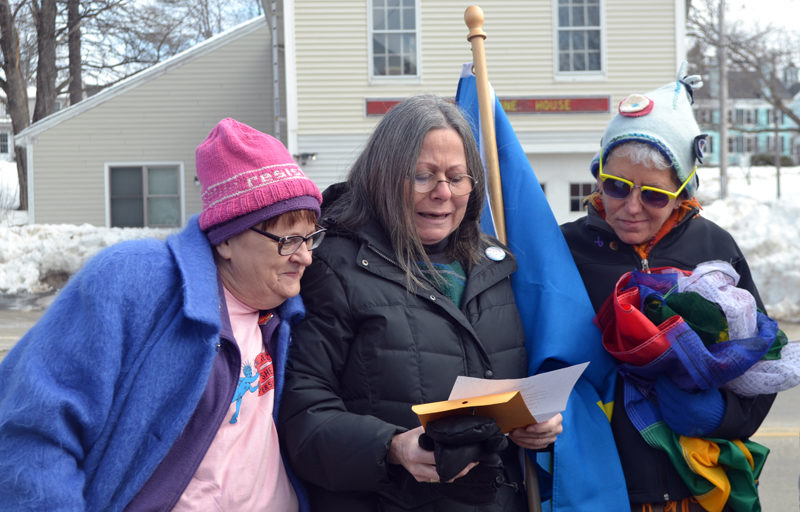 Daphne Lehava Stern (center) reads "The New Colossus," a poem writen by Emma Lazarus in 1883 for the construction of the Statue of Liberty's pedestal, as Eleanor Cade Busby (left) and Sharon Sandstrum look on. (Maia Zewert photo)