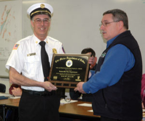 Somerville Fire Chief Mike Dostie accepts the Safety and Health Award for Public Employers from Michael LaPlante, of the Maine Department of Labor, at the Somerville town office Wednesday, March 1. (Alexander Violo photo)