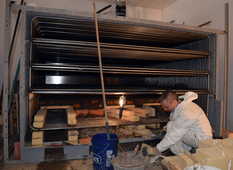 Norbert Creutzer works on the masonry for the new oven at Borealis Breads in Waldoboro on Friday, March 3. Creutzer works for the French manufacturer and traveled to Waldoboro to assemble the oven, a job that includes electrical work, masonry, and welding. (J.W. Oliver photo)