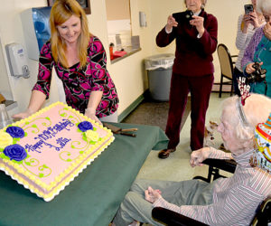 Country Manor Nursing Home Activities Director Tammy Brann shows Lillie Weissenberger her 100th birthday cake Monday, March 27. (Abigail Adams photo)