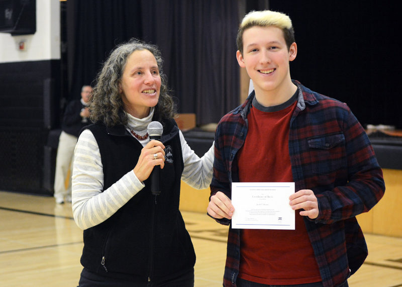 Lincoln Academy senior Jacob Brown stands with Lincoln Academy Director of Counseling and Studies Sarah Wills-Viega, who presented him with his National Merit finalist certificate at the Lincoln Academy community meeting on Friday, March 3.
