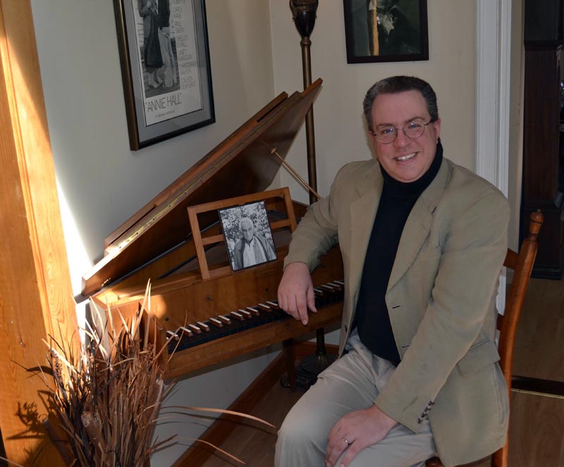 Aaron Robinson sits at his harpsichord in his Alna home on Friday, April 14. The harpsichord has a picture of Leonard Bernstein on it. (Abigail Adams photo)