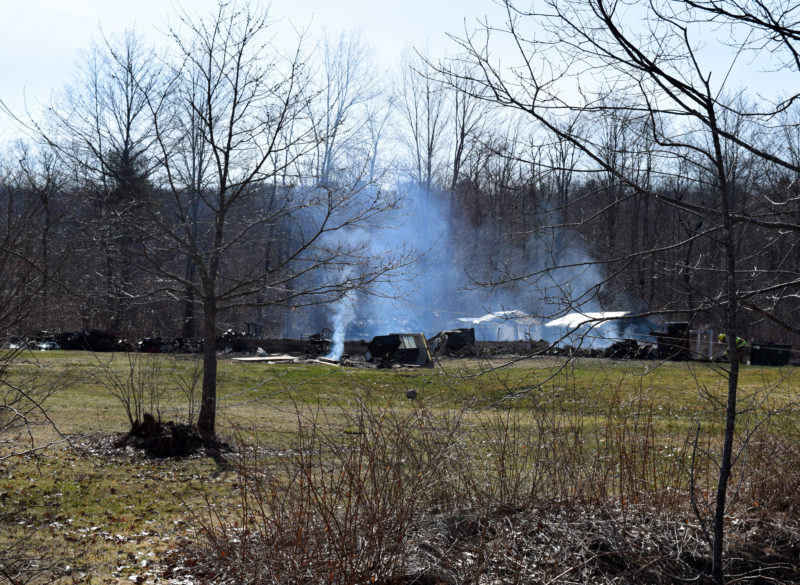 The remains of a building smolder on Pension Ridge Road in Boothbay the morning of Saturday, April 15. (J.W. Oliver photo)