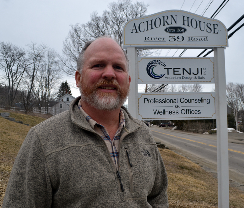 Tenji Aquarium Design + Build co-owner Edward "Ed" Seidel stands in front of the company's sign for its East Coast office at 39 River Road in Newcastle. (Maia Zewert photo)