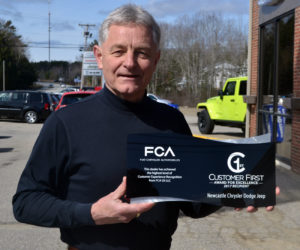 Newcastle Chrysler Dodge Jeep President Randy Miller holds the dealership's Customer First Award for Excellence. (Maia Zewert photo)