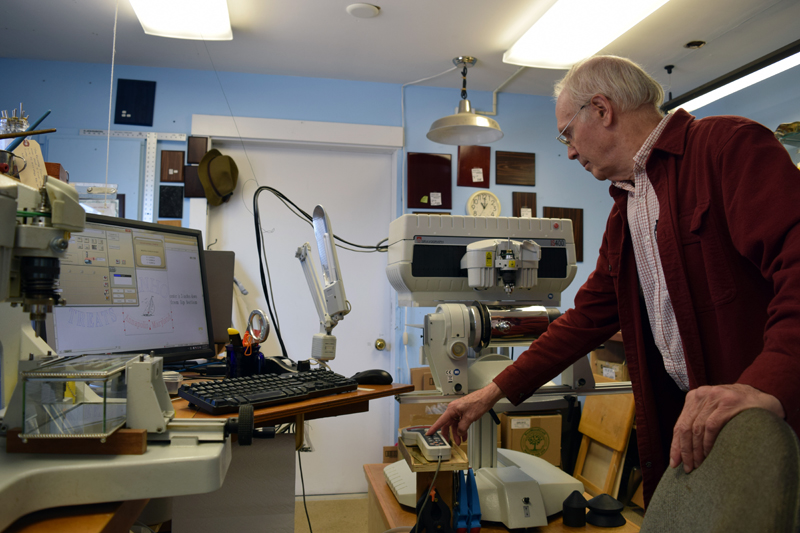 John Day demonstrates some of the equipment at Emporium Engraving in Newcastle on Friday, April 14. (J.W. Oliver photo)