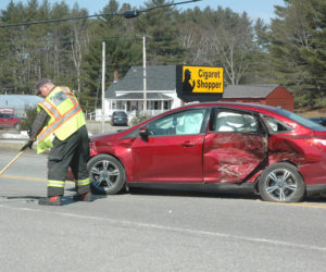 A member of the Waldoboro Fire Department sweeps debris out of the road at the scene of a three-car collision on Route 1 the morning of Monday, April 10. (Alexander Violo photo)