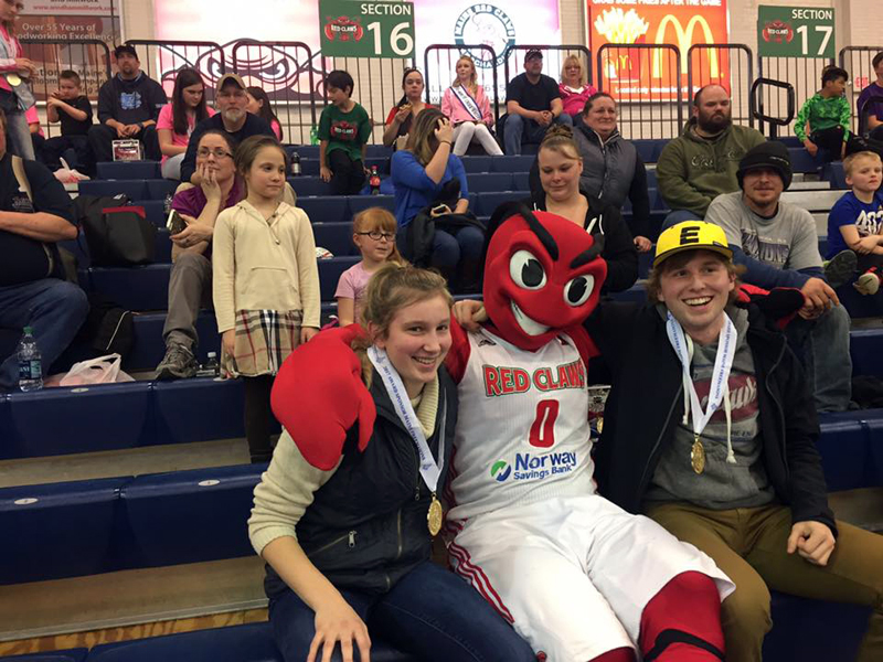 Lincoln Academy students Brie Wajer (front left) and Evan Eckel (right), CLC Y youth board members for 2015-2017, celebrate at the March 26 Maine Red Claws youth-volunteer recognition game, where they were each presented with a service certificate and a Maine Volunteer Service medallion.