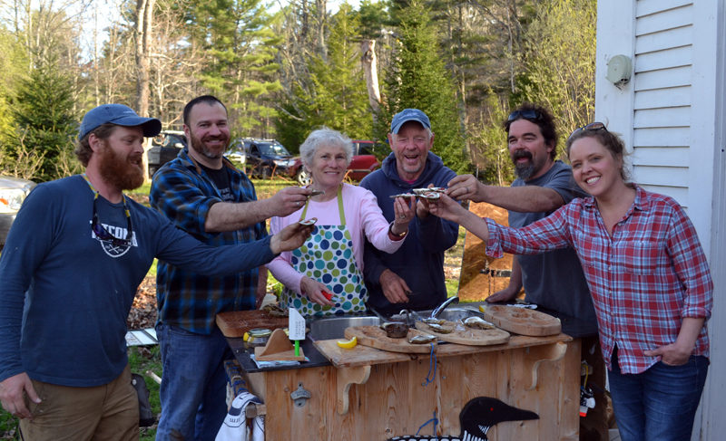 From left: Chase Morrill, Adam Myer, Sharon and Leigh Morrill, Ryan Eldridge, and Ashley Morrill-Eldridge enjoy oysters at the Morrills' home after completing filming for "Maine Cabin Masters" for the day Friday, April 28. (Abigail Adams photo)