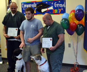 From left: Dustin Campbell, Coastal Humane Society trainer Mike Gould, and Norman Palmer present recue dogs Jake (left) and Melvin with certificates of completion upon their graduation from Two Bridges Regional Jail's new dog obedience program Tuesday, May 23. (Abigail Adams photo)