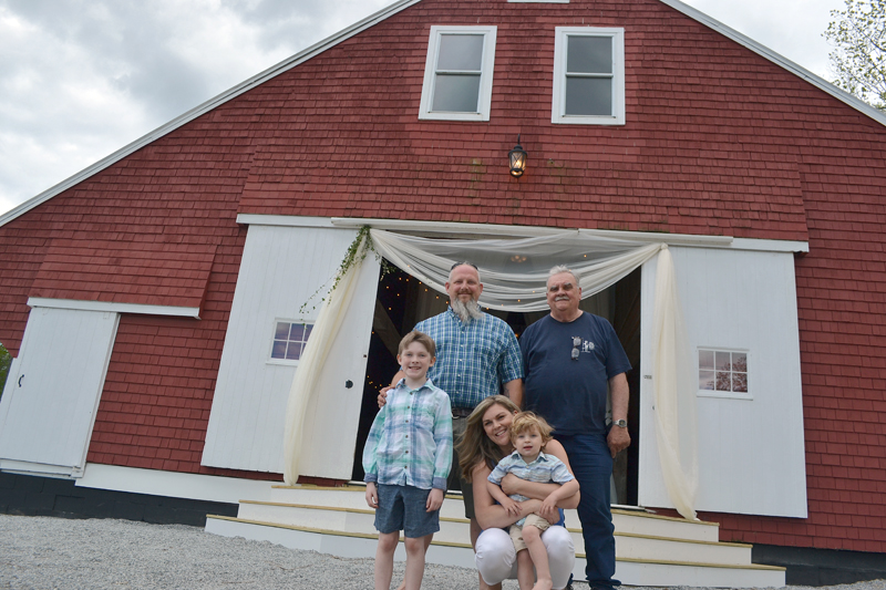 Paul and Meredith Blakesley, their sons, William and Oliver, and Meredith's father, Jim Grimes, stand in front of The Lakeside Barn, a new event venue at Duck Puddle Campground in Nobleboro. The Blakesleys and Jim and Mary Grimes own the campground. (Maia Zewert photo)