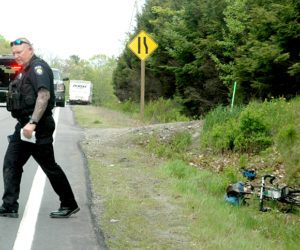 Officer Larry Hesseltine, of the Waldoboro Police Department, investigates the scene of a truck vs. bicycle collision on Route 1 in Waldoboro the afternoon of Wednesday, May 24. (Alexander Violo photo)