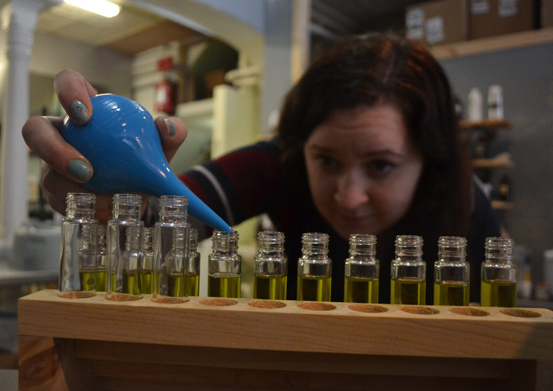 Long Winter Soap Co. employee Kat Rogers fills bottles of perfume at the company's new location at 11 Friendship St. in Waldoboro. Long Winter Soap Co. also sells soap, lip balm, body cream, and other body care products. (Maia Zewert photo)