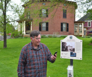 Ed Kavanagh holds a mobile phone in front of his home, the Octagon House, one of the stops on Wiscasset's Museum in the Streets tour, on Thursday, May 25. The tour is now available as an app. (Abigail Adams photo)