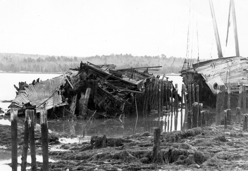 The Hesper, a four-masted schooner built in the early 1900s, appears as a pile of picked-over rubble on the Wiscasset waterfront in this 1990 photograph. At right is the Luther Little. (LCN file photo)