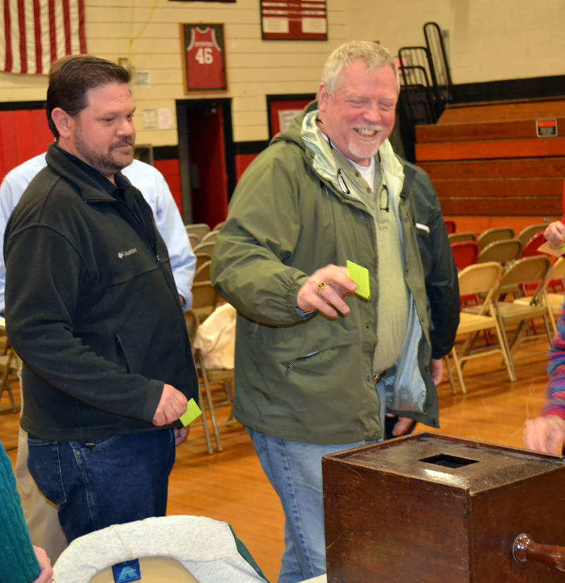 Wiscasset School Committee Chair Michael Dunn (left) and committee member Glen Craig vote by secret ballot on the Wiscasset School Department budget at the annual budget meeting Monday, May 15. (Abigail Adams photo)