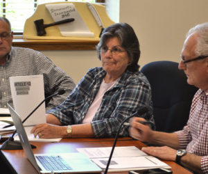 Damariscotta Board of Selectmen Chair Robin Mayer holds up a copy of the Damariscotta SmartCode, a form-based code voters rejected in June 2011, while Town Manager Matt Lutkus (left) and Selectman Ronn Orenstein look on during a workshop Wednesday, June 7. (Maia Zewert photo)