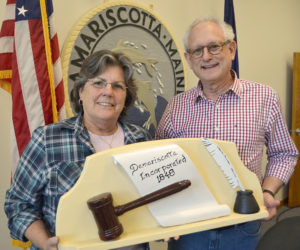 Damariscotta Board of Selectmen Chair Robin Mayer and Vice Chair Ronn Orenstein hold a 1959 wood carving by the late Damariscotta artist Maurice "Jake" Day. The carving, along with the town seal behind Mayer and Orenstein, were both carved by Jake Day in 1959 and restored by his grandson Dan Day. (Maia Zewert photo)