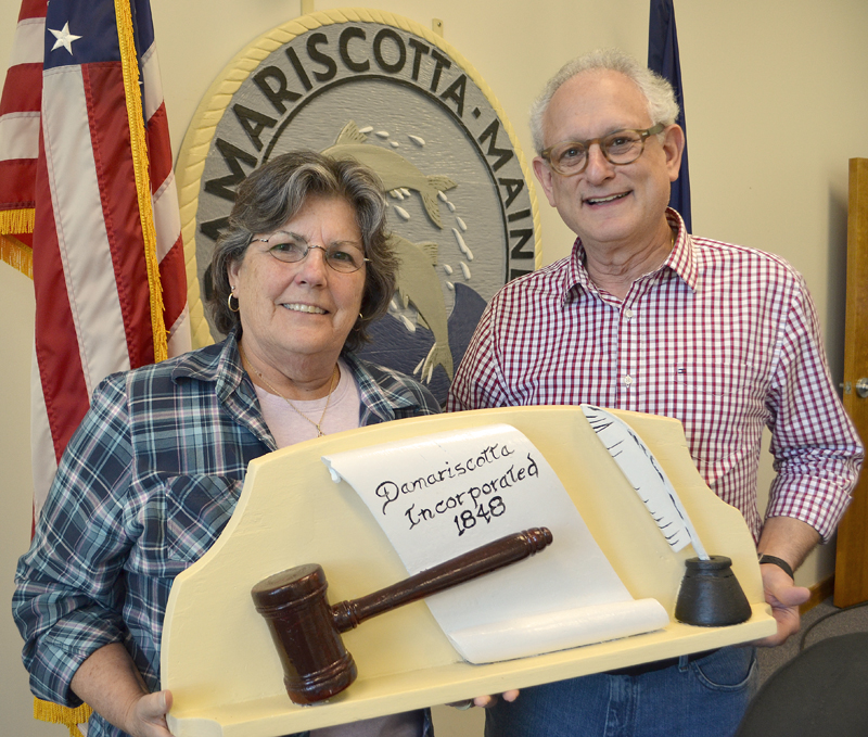 Damariscotta Board of Selectmen Chair Robin Mayer and Vice Chair Ronn Orenstein hold a 1959 wood carving by the late Damariscotta artist Maurice "Jake" Day. The carving, along with the town seal behind Mayer and Orenstein, were both carved by Jake Day in 1959 and restored by his grandson Dan Day. (Maia Zewert photo)