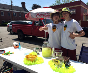 Friends and business partners Dylan Squiers (left) and Dawson French at their lemonade stand, Sugar Daddy's Lemonade, in Damariscotta on Monday, June 12. French designed and made their shirts. (Maia Zewert photo)