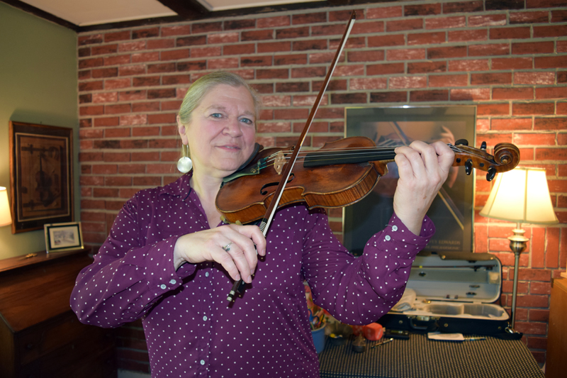 Preston Music Studio owner Carol Preston poses with her violin, one of the instruments she teaches her students how to play. (Remy Segovia photo)