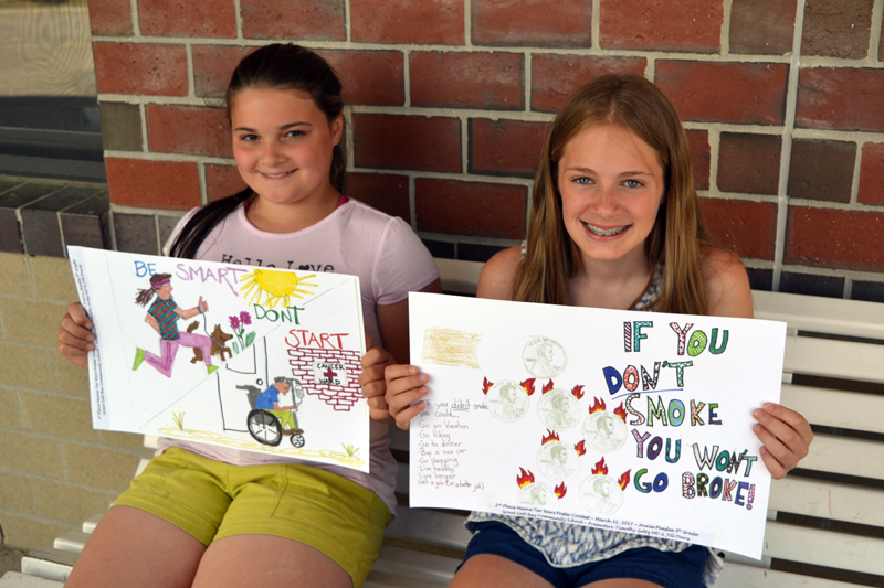 Emory Shadis (left) and Annie Peaslee, both 11-year-old fifth-graders at Great Salt Bay Community School in Damariscotta, hold up the posters that netted them first and second place, respectively, in the Maine Academy of Family Physicians' staewide "Tar Wars" poster contest. (Christine LaPado-Breglia photo)