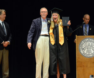 Lincoln Academy senior Esther Martin receives her diploma in a black graduation gown from adviser Robert Breckenridge on June 1, as Head of School David Sturdevant (left) and Associate Head of School Andy Mullin look on. (Photo courtesy Lincoln Academy)