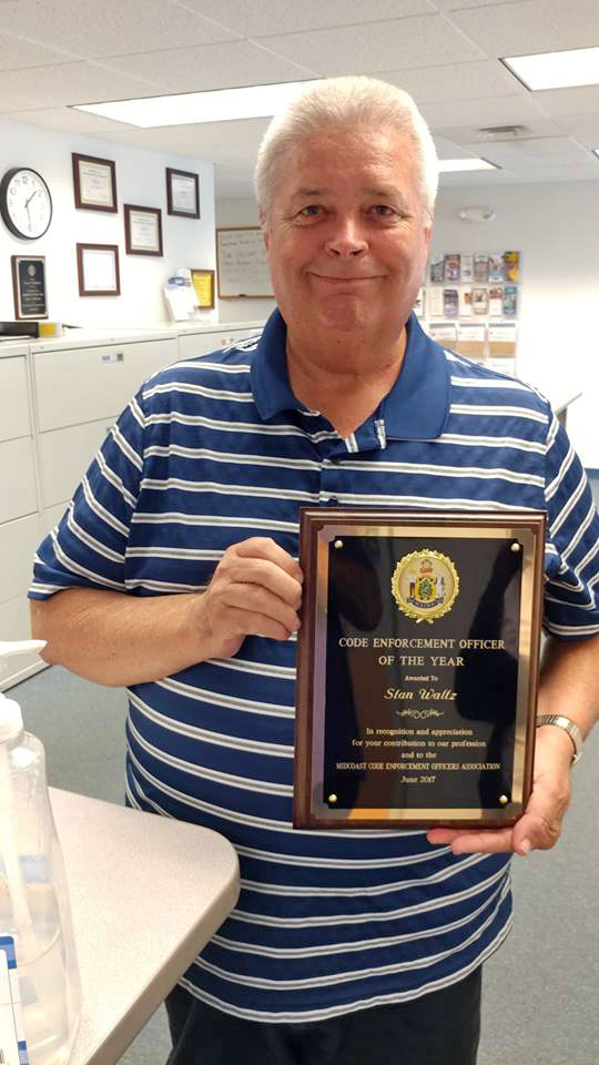 Stan Waltz holds his Code Enforcement Officer of the Year plaque from the Midcoast Code Enforcement Officers Association. (Photo courtesy Julie Keizer)