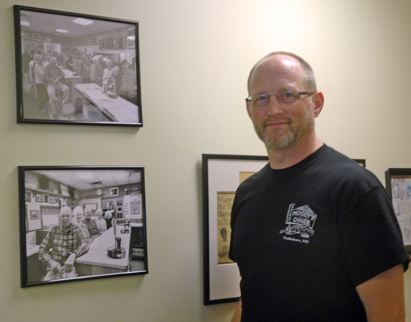 Moody's Diner co-owner Dan Beck, a grandson of founders Percy and Bertha Moody, stands next to photographs of the family. (Alexander Violo photo)