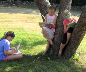 From left: Harriet McKane, Addie Miller, and Piper McKane enjoy the shade at the Old Jail in Wiscasset while writing in their journals during last years Summer with the Past program.