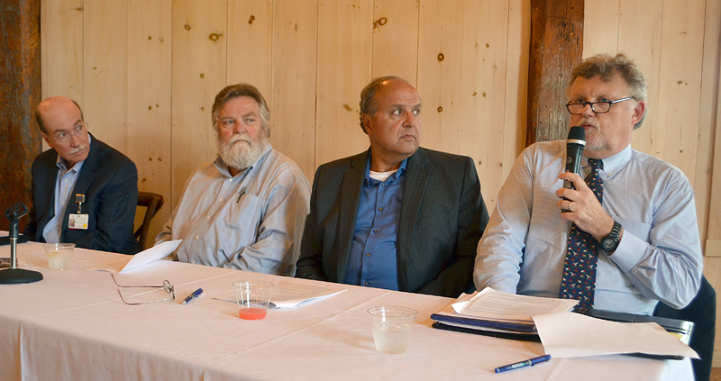 From left: LincolnHealth President and CEO Jim Donovan, LincolnHealth Chief Medical Officer Dr. Russ Mack, and MaineHealth President Bill Caron look on as LincolnHealth Board of Trustees Chair Bill Logan speaks during a public meeting about the MaineHealth unification proposal Wednesday, July 12. (Maia Zewert photo)