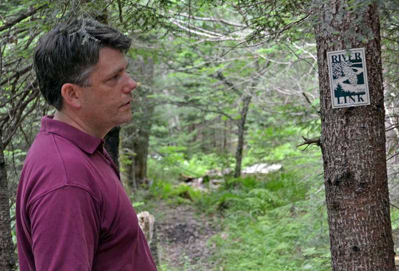 Damariscotta River Association Executive Director Steve Hufnagel looks at the marker for the River-Link Trail on the Barrows Louderback Preserve in Edgecomb on Monday, July 10. (Abigail Adams photo)