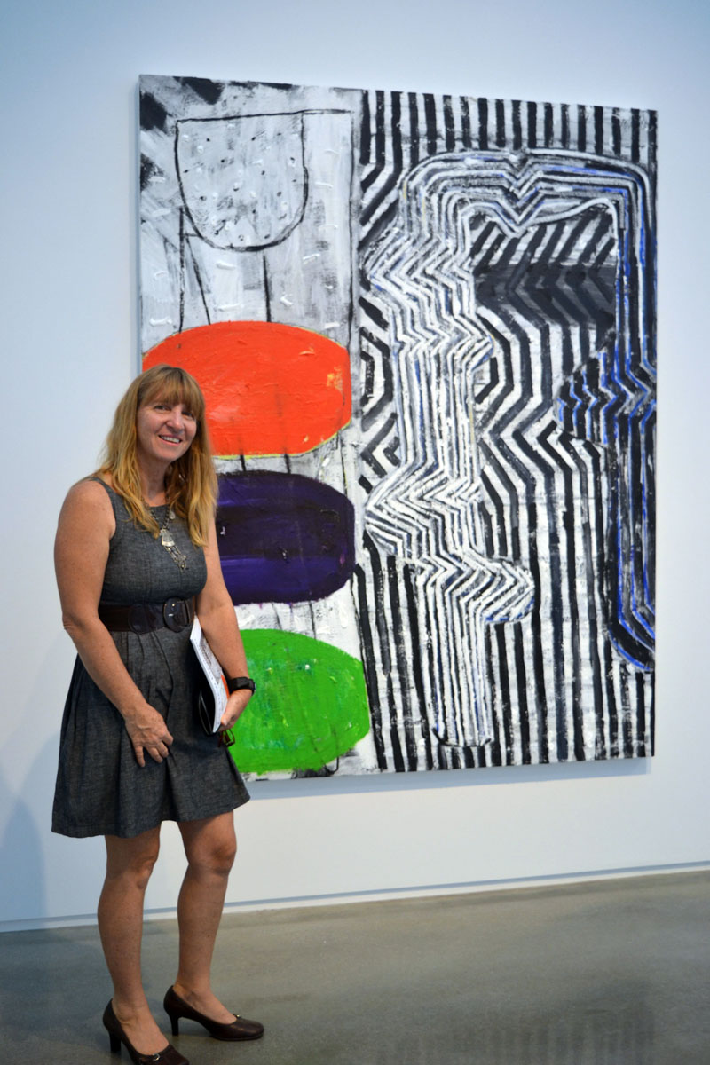 Jackie Guillerm, wife of Waldoboro artist Philippe Guillerm, stands before "Move," a painting by Seal Point painter John Walker, at the July 20 launch party for Art New England Magazine's July/August issue at the Center for Maine Contemporary Art in Rockland. (Christine LaPado-Breglia photo)