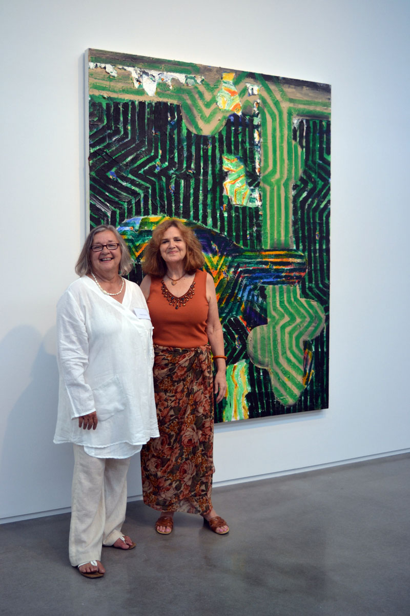 From left: Yvette Torres, of Yvette Torres Fine Art in Rockland, and Jefferson resident Kay Liss enjoy the festivities at the July 20 launch party for Art New England Magazine's July/August issue. Behind them hangs Seal Point artist John Walker's oil painting titled "Wait." (Christine LaPado-Breglia photo)