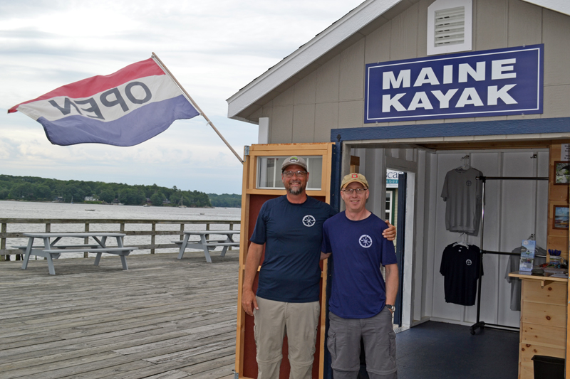 Maine Kayak owner Alvah Maloney and employee Hauns Bassett stand in front of the rental office on the Creamery Pier in Wiscasset on Friday, July 7. (Abigail Adams photo)