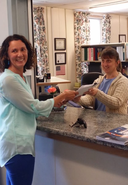 Wiscasset Area Chamber of Commerce member Sherri Dunbar (left) turns in a petition calling for a reinstatement of the town planning department to Town Clerk Linda Perry on Wednesday, July 5. (photo courtesy Kathy Onorato)