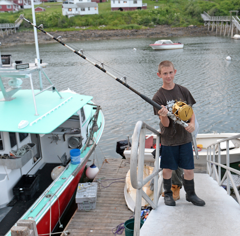 Myles Wotton, 12, with his father's 25-year-old rod and reel, which he used to catch a 450-pound tuna Monday after a five-hour battle. (Paula Roberts photo)