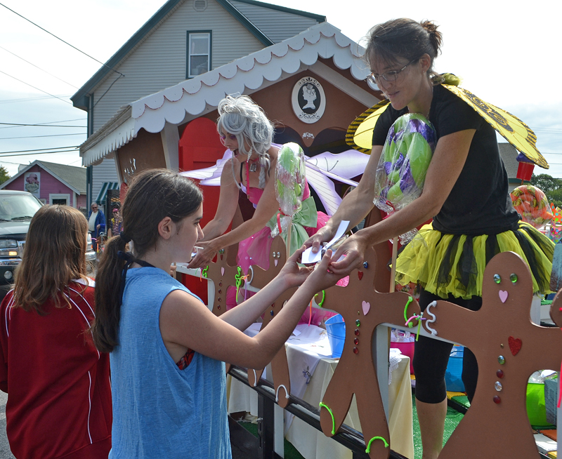 April Morrison (left) and Jessica Yates pass out cookies from the SugarSpell Sweets float during the Olde Bristol Days parade Saturday, Aug. 12. The float, which resembled a gingerbread house, took first place. (Maia Zewert photo)