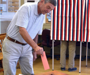 Bristol resident Jim Albright casts his vote during a special town meeting Tuesday, Aug. 22. (Maia Zewert photo)