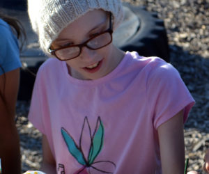 Alice Skiff, of Newcastle, paints a rock with a gold ribbon, the symbol for childhood cancer awareness, at the Great Salt Bay Community School playground Monday, Aug. 28. (Maia Zewert photo)