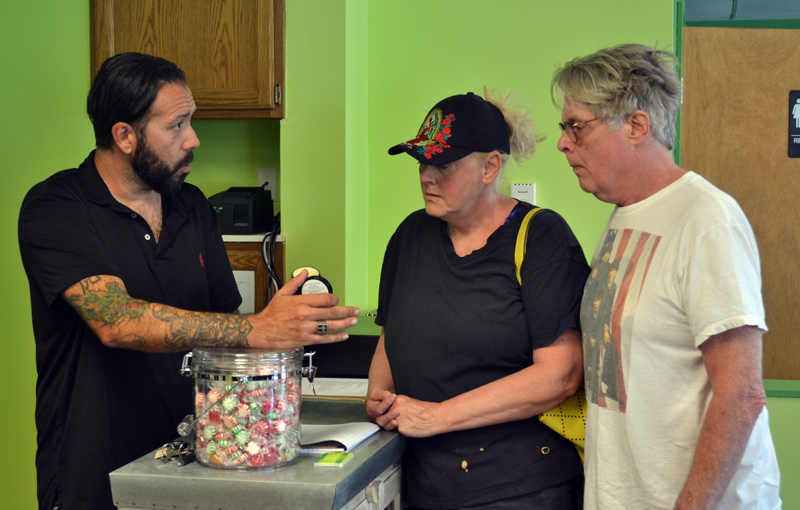 Downeast Medicinals co-owner David Boucher (left) shows Elaine and Ralph Bryant a cannabidiol body lotion for sale at the Edgecomb business Monday, Aug. 21. (Abigail Adams photo)